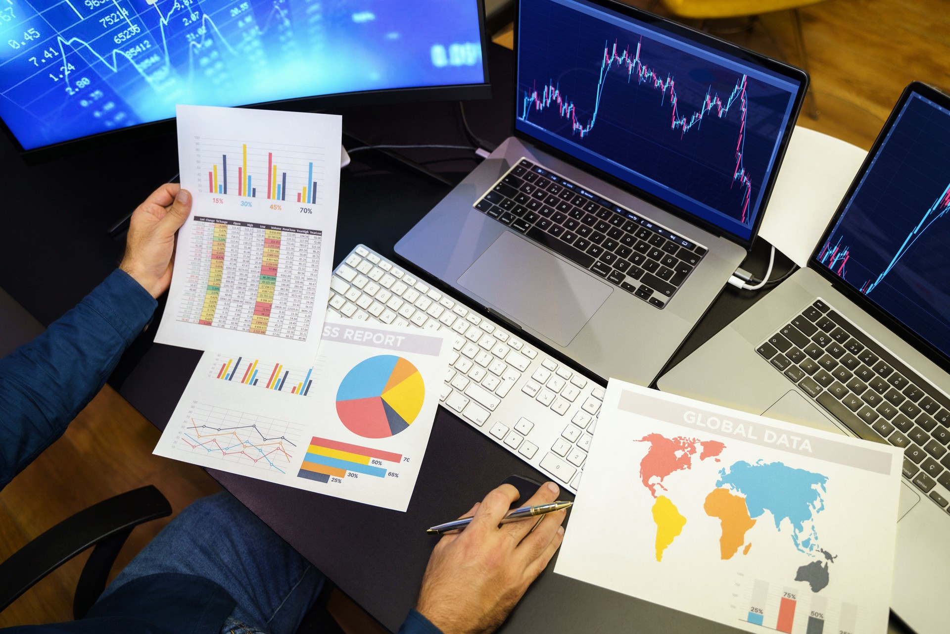 Businessman analyzing crypto currency market graphs on computer and laptop screen